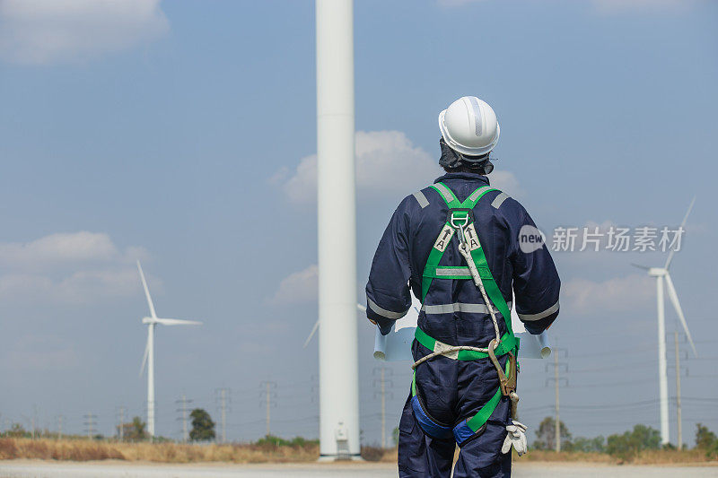 man engineer worker wearing safety uniform holding and reading blueprint working about renewable energy at station energy power wind. technology protect environment reduce global warming problems.